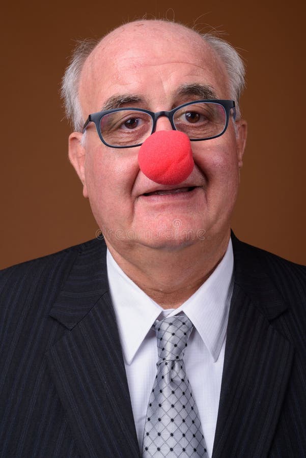 Homme d'affaires supérieur de poids excessif portant le nez rouge de clown images libres de droits Homme d'affaires supérieur de poids excessif portant le nez rouge de clown images libres de droits