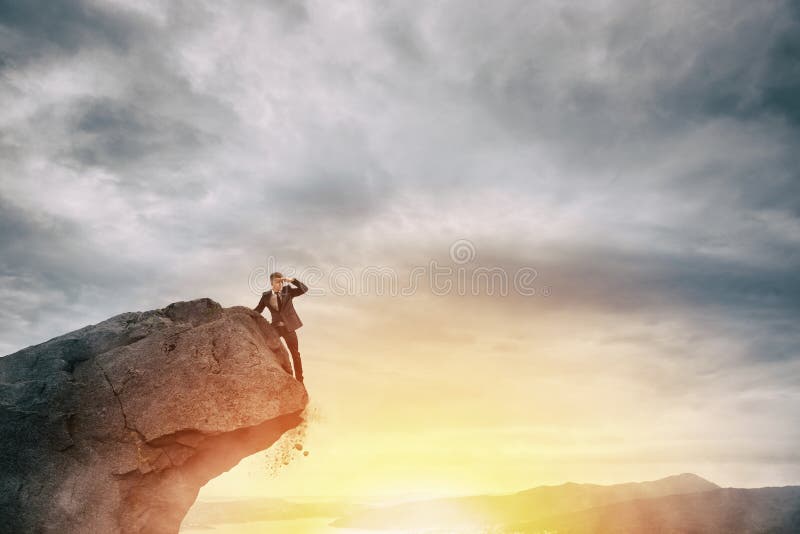 Homme d'affaires sur la crête d'une montagne pour trouver des affaires nouvelles photo stock Homme d'affaires sur la crête d'une montagne pour trouver des affaires nouvelles photo stock