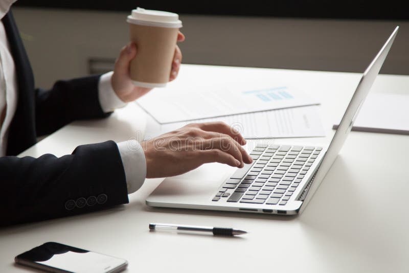 Homme d'affaires travaillant avec l'ordinateur portable et les documents sur le lieu de travail, clos photographie stock Homme d'affaires travaillant avec l'ordinateur portable et les documents sur le lieu de travail, clos photographie stock
