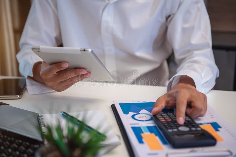 Homme d'affaires travaillant sur calculateur pour calculer les données financières rapport comptable document et ordinateur portable au bureau concept d'entreprise.