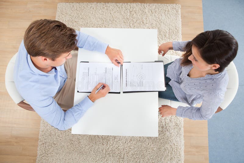 Homme d'affaires vérifiant le résumé du candidat féminin photo stock Homme d'affaires vérifiant le résumé du candidat féminin photo stock