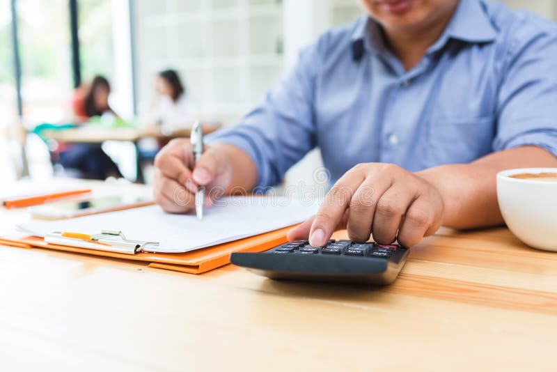 Homme d'affaires à l'aide de la calculatrice au calcul images stock Homme d'affaires à l'aide de la calculatrice au calcul images stock