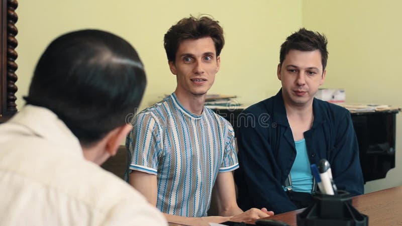 Homme dans l'argumentation fâchée de filet de cheveux avec deux visiteurs lors de la réunion de bureau