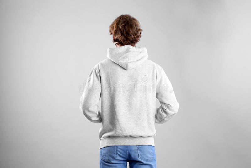 Homme dans le chandail de hoodie sur le fond clair photo libre de droits Homme dans le chandail de hoodie sur le fond clair photo libre de droits