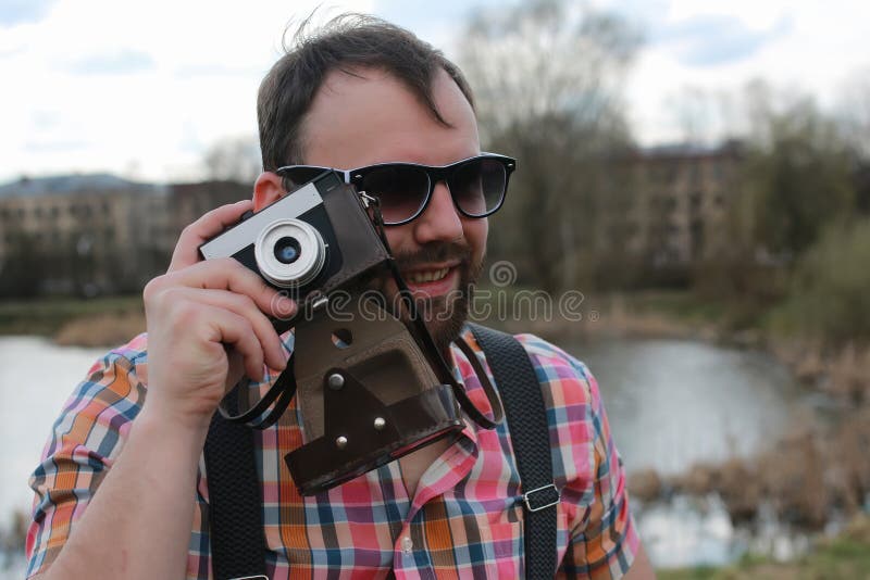Homme de barbe avec le rétro appareil-photo en parc