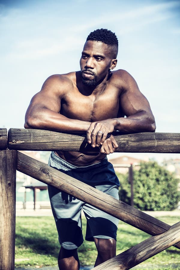 Homme de couleur sans chemise musculaire en parc photographie stock libre de droits Homme de couleur sans chemise musculaire en parc photographie stock libre de droits