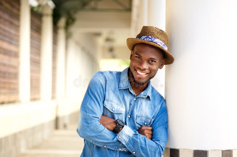 Homme de sourire d'afro-américain détendant avec des bras croisés image stock Homme de sourire d'afro-américain détendant avec des bras croisés image stock