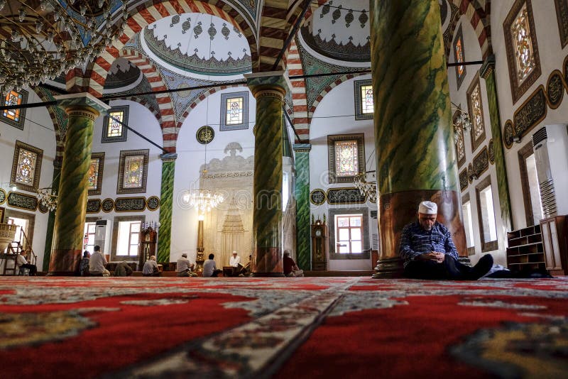 Homme dormant dans une mosquée se penchant contre un pilaire image stock Homme dormant dans une mosquée se penchant contre un pilaire image stock