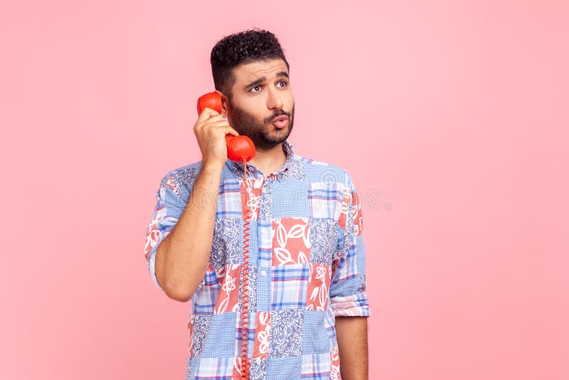 Homme drôle avec barbe en bleu casual style chemise tenant téléphone combiné avoir une conversation incroyable nouvelles debout av images libres de droits
