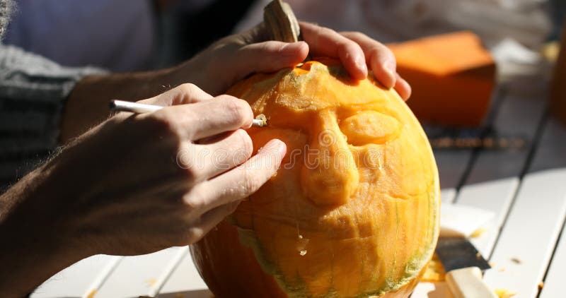 Homme découpant le potiron de Helloween