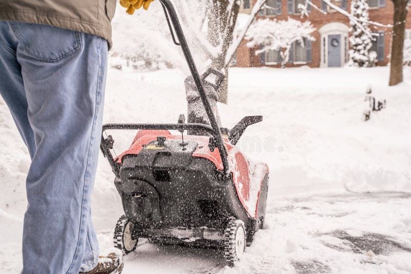Berks County, Pennsylvania-February 2, 2021:  Senior man using a snow blower to clear his sidewalk and driveway after snowstorm. Berks County, Pennsylvania-February 2, 2021:  Senior man using a snow blower to clear his sidewalk and driveway after snowstorm