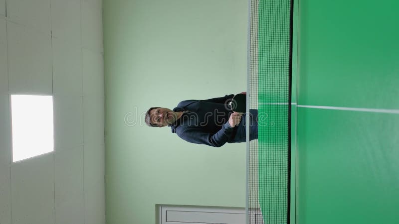 Homme démontrant des compétences en ping-pong dans une installation couverte verte. vidéo verticale banque de vidéos