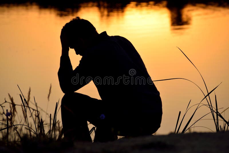 Homme déprimé s'asseyant sur des mains images stock Homme déprimé s'asseyant sur des mains images stock