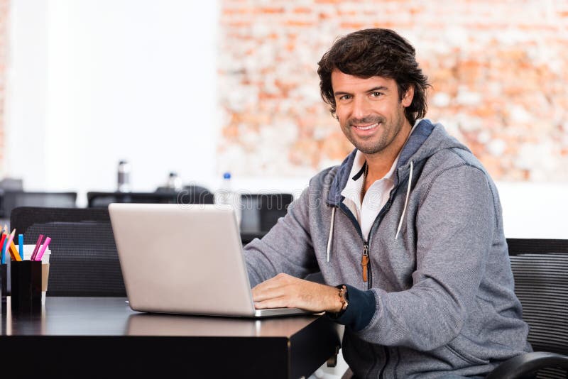 Man using laptop casual businessman smile sitting office desk working. Man using laptop casual businessman smile sitting office desk working