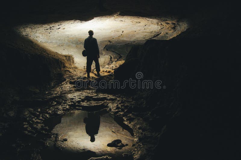 Silhouette of man exploring in underground dark cave. Silhouette of man exploring in underground dark cave