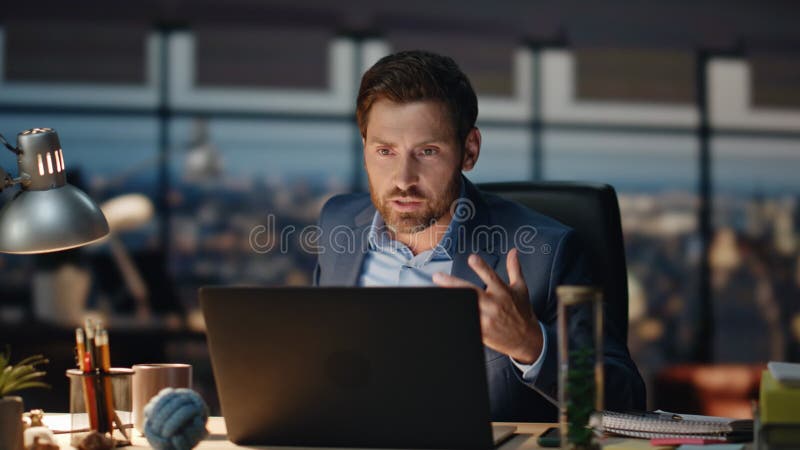 Homme en colère se disputant vidéocall au closeup intérieur du soir. homme d'affaires qui parle