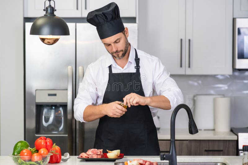 Homme En Tablier De Cuisinier Et Chapeau De Chef à La Cuisine Moderne  Préparant Du Poisson Saumon Bel Homme Cuisine Frais