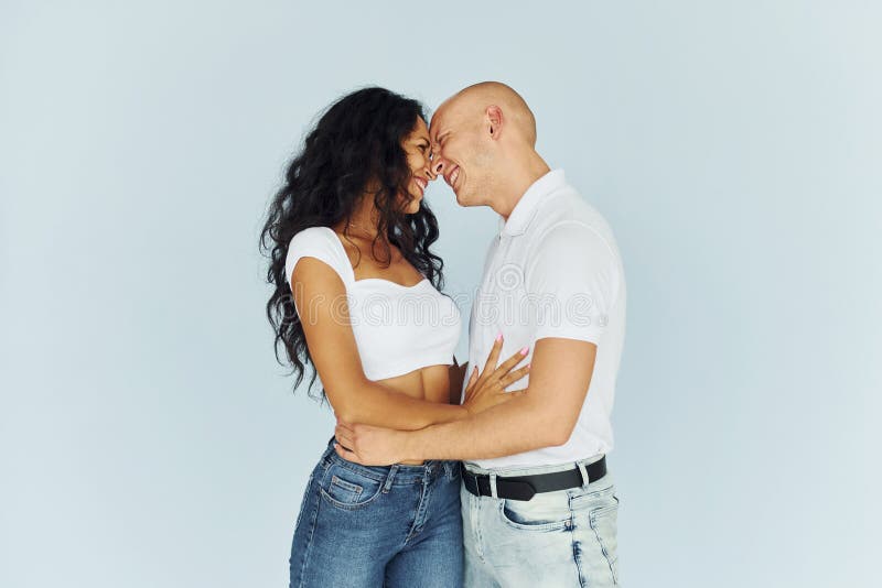 Homme en vêtements blancs et femme en jeans. couple joyeux à l'intérieur photo libre de droits