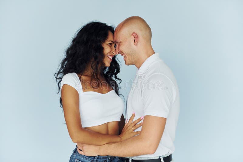Homme en vêtements blancs et femme en jeans. couple joyeux à l'intérieur image stock