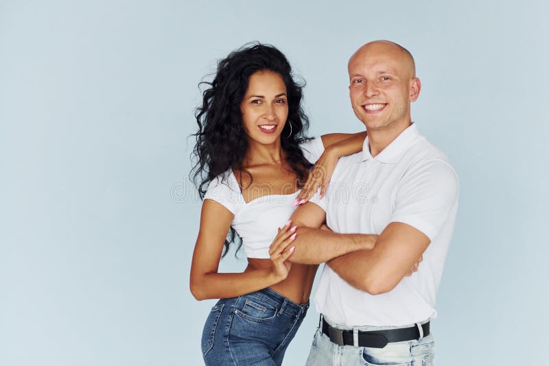 Homme en vêtements blancs et femme en jeans. couple joyeux à l'intérieur photos libres de droits