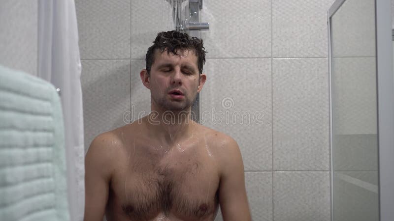 Homme endormi se lave dans la douche. une personne fatiguée prend la douche et essaie de se réveiller. réveil matinal