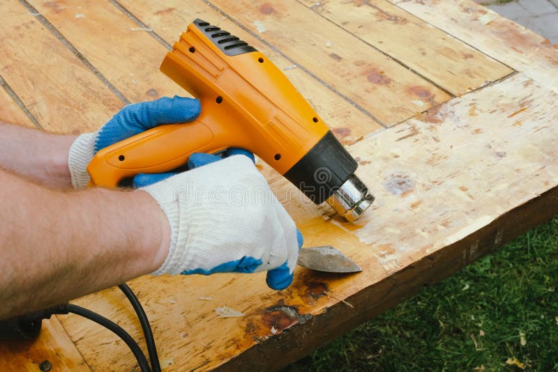 https://thumbs.dreamstime.com/b/homme-enlever-vieux-vernis-du-bois-%C3%A0-l-aide-de-racleur-et-pistolet-chaleur-peinture-restauration-d-une-vieille-table-en-253062682.jpg