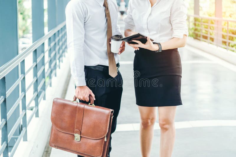 Homme et femme d'affaires avec la tablette se tenant parlante et photographie stock libre de droits Homme et femme d'affaires avec la tablette se tenant parlante et photographie stock libre de droits