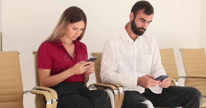 Homme et femme lisent des messages et des notifications sur les téléphones banque de vidéos