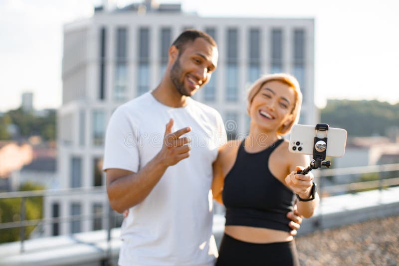 Homme et femme sportif écrivant un blog avec téléphone sur le toit. photo libre de droits