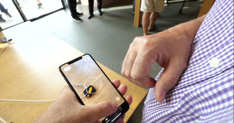 Homme examinant la nouvelle caractéristique de la bande APP de l'AR dans l'iPhone XS