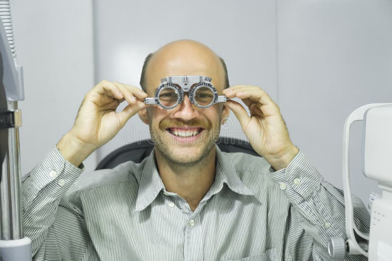 Homme examinant la vue dans la clinique optique. photos stock