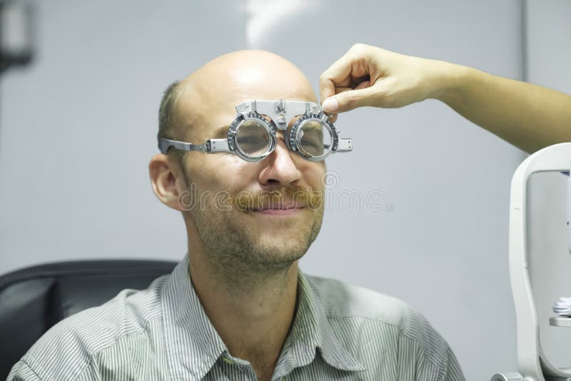 Homme examinant la vue dans la clinique optique. photographie stock libre de droits