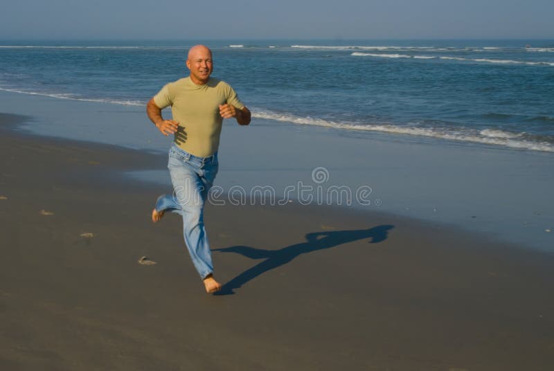 Man (bab-boomer) running on the beach on a summer day. Man (bab-boomer) running on the beach on a summer day