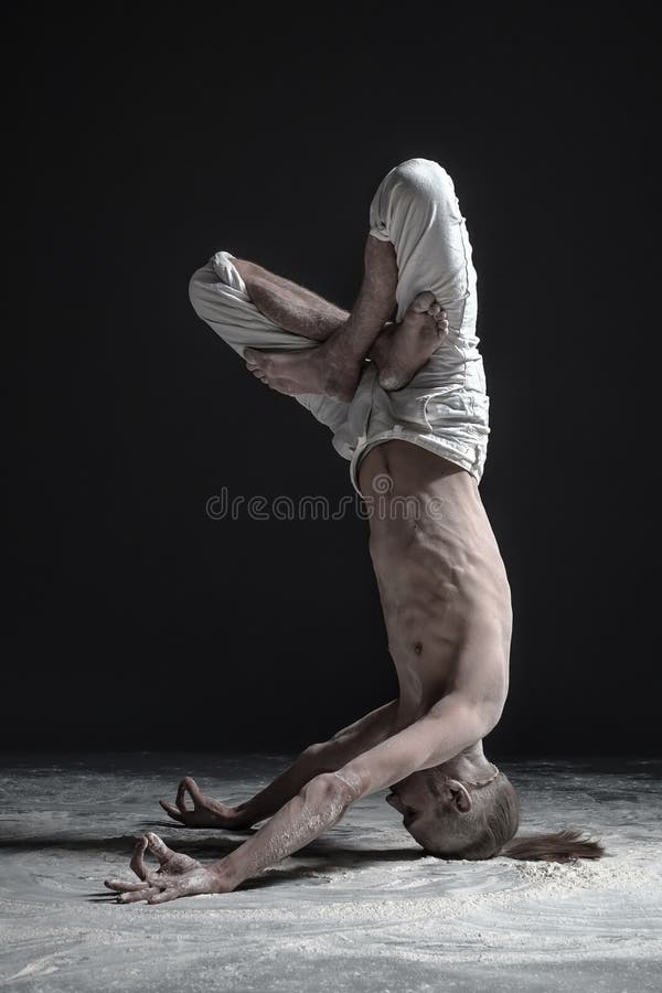 Homme flexible de yoga se tenant dans la pose de headstand de shirshasana de yoga images libres de droits Homme flexible de yoga se tenant dans la pose de headstand de shirshasana de yoga images libres de droits
