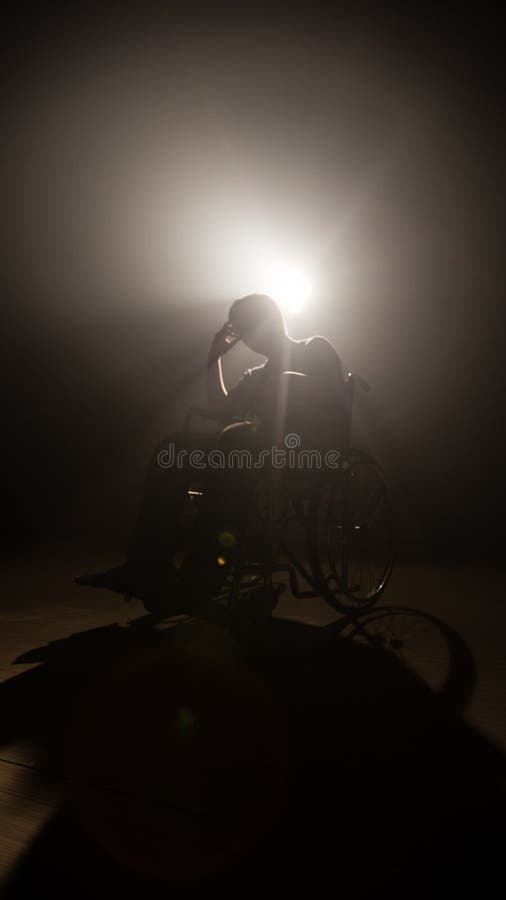 Homme foncé de silhouette sur le fauteuil roulant à l'étape de mystère la production et la cinématographie visuelles avec le film photos libres de droits Homme foncé de silhouette sur le fauteuil roulant à l'étape de mystère la production et la cinématographie visuelles avec le film photos libres de droits