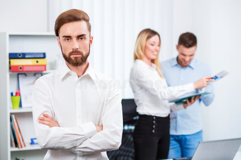 Homme futé heureux d'affaires avec des compagnons d'équipe photographie stock libre de droits Homme futé heureux d'affaires avec des compagnons d'équipe photographie stock libre de droits