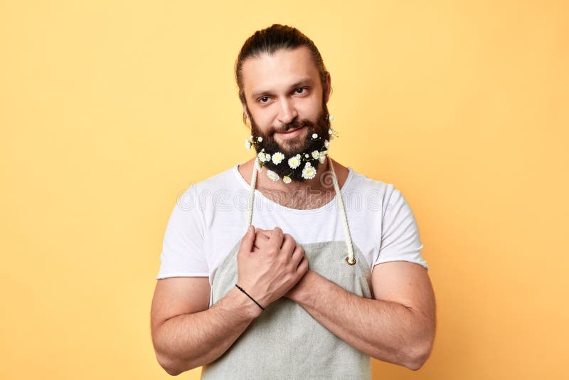 Homme gai barbu attirant et brutal avec des fleurs dans la barbe image libre de droits Homme gai barbu attirant et brutal avec des fleurs dans la barbe image libre de droits