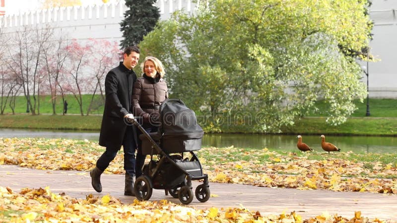 Homme heureux et jolie femme marcher avec bébé banque de vidéos