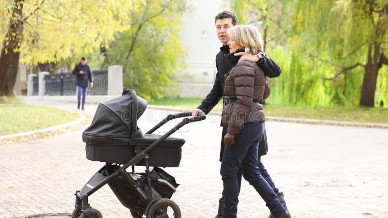 Homme heureux et jolie femme marcher avec bébé banque de vidéos