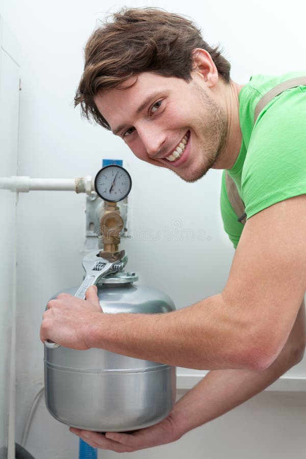 Homme heureux réparant la chaudière photo libre de droits Homme heureux réparant la chaudière photo libre de droits