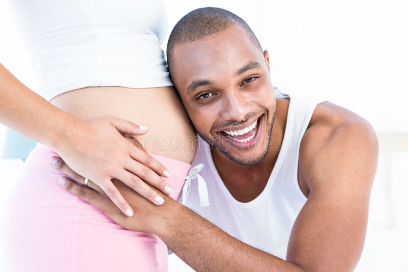 Homme heureux écoutant le ventre de l'épouse enceinte photos stock Homme heureux écoutant le ventre de l'épouse enceinte photos stock