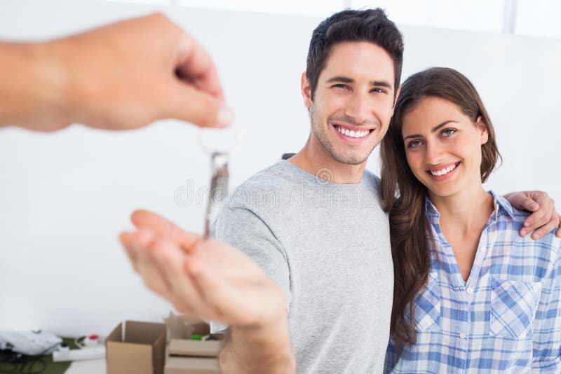 Homme heureux étant donné une clé de maison photographie stock