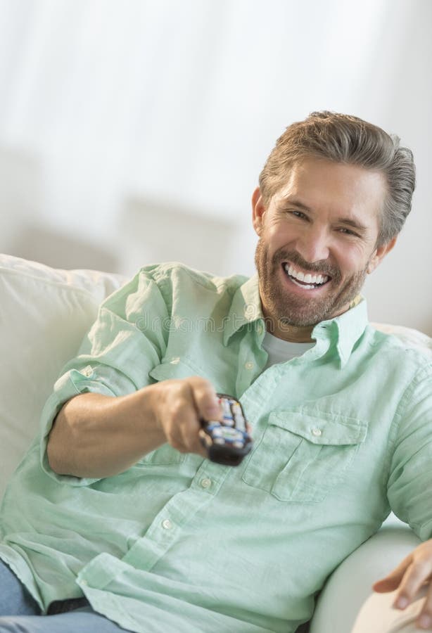 Homme mûr regardant la TV sur le sofa photo libre de droits Homme mûr regardant la TV sur le sofa photo libre de droits