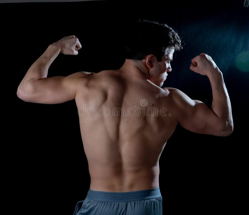Homme musclé de jeune forme physique montrant le sien muscles de retour, d'épaules, de triceps et de biceps après la formation photographie stock Homme musclé de jeune forme physique montrant le sien muscles de retour, d'épaules, de triceps et de biceps après la formation photographie stock
