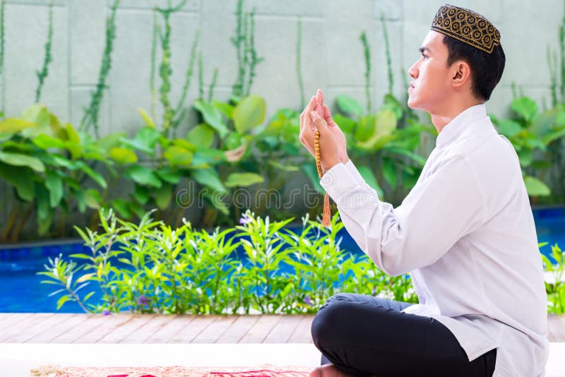Homme musulman asiatique priant sur le tapis photo stock Homme musulman asiatique priant sur le tapis photo stock