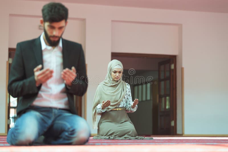 Homme musulman et femme priant dans la mosquée photo libre de droits Homme musulman et femme priant dans la mosquée photo libre de droits