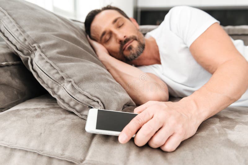 Homme mûr bel dormant sur un divan photo libre de droits Homme mûr bel dormant sur un divan photo libre de droits