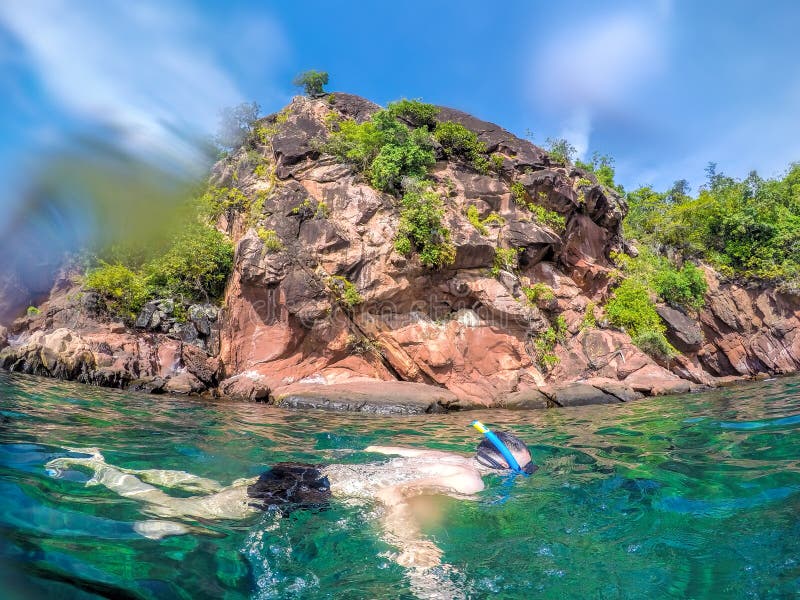 Homme naviguant au schnorchel dans l'eau clair comme de l'eau de roche en Thaïlande photo libre de droits Homme naviguant au schnorchel dans l'eau clair comme de l'eau de roche en Thaïlande photo libre de droits