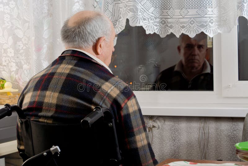 Homme plus âgé dans un fauteuil roulant attendant à une fenêtre photos stock Homme plus âgé dans un fauteuil roulant attendant à une fenêtre photos stock