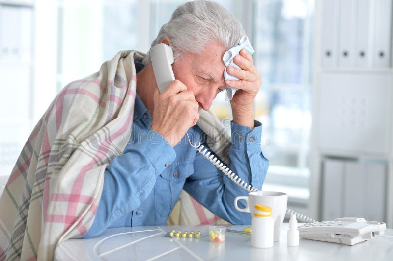 Homme plus âgé malade appelant par le téléphone photos libres de droits Homme plus âgé malade appelant par le téléphone photos libres de droits